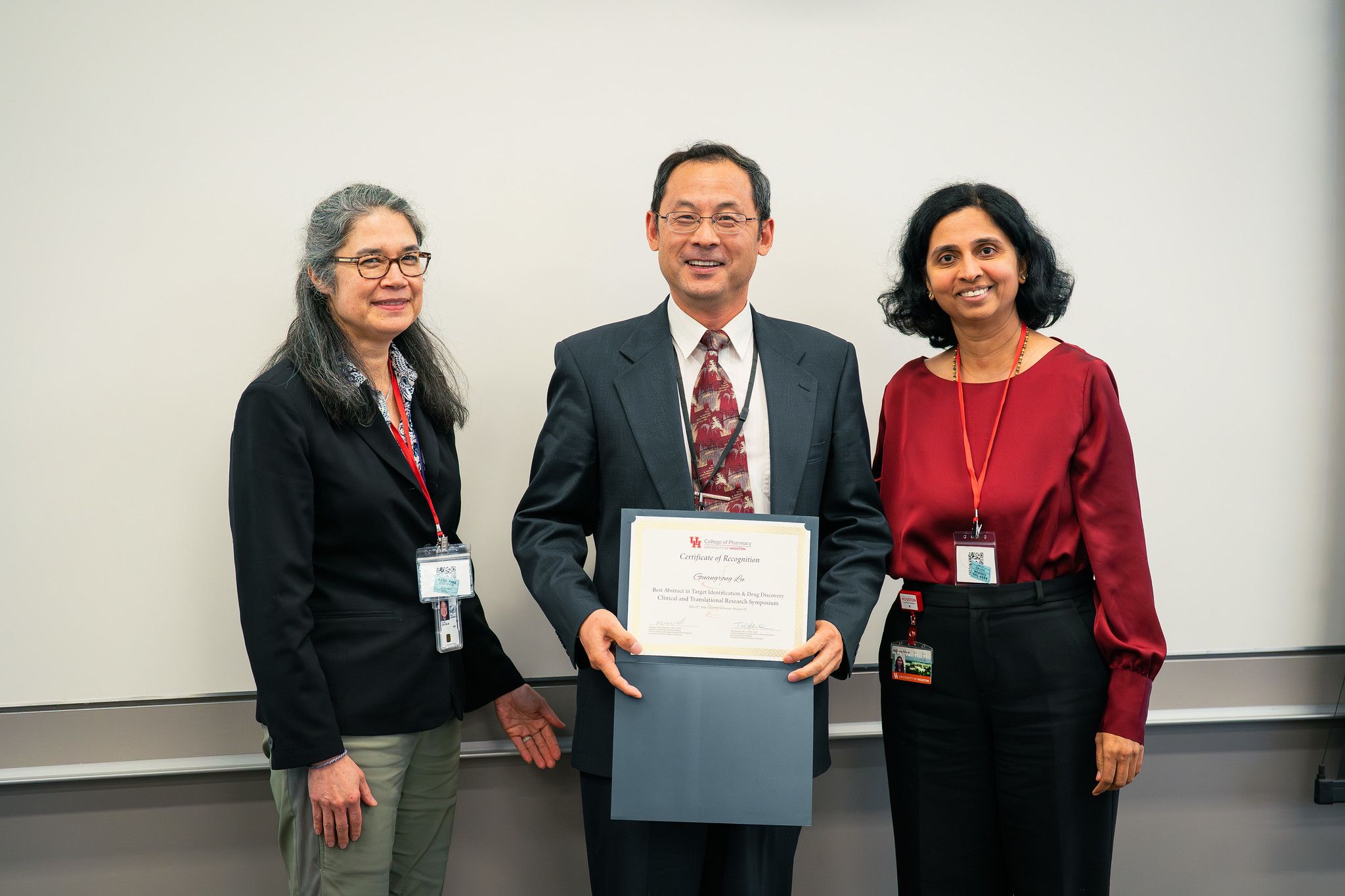 Dr. Guangrong Lu receiving Best Abstract recognition with two symposium organizers at CTRS 2026.